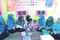 Ketua TP-PKK Sumenep, Nia Kurnia Fauzi, saat menyerahkan langsung bantuan olahan ikan kepada anak terdampak stunting di Desa Kalianget Timur. (Foto:Klik Times). 