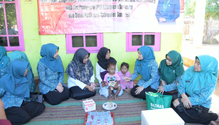 Ketua TP-PKK Sumenep, Nia Kurnia Fauzi, saat menyerahkan langsung bantuan olahan ikan kepada anak terdampak stunting di Desa Kalianget Timur. (Foto:Klik Times). 