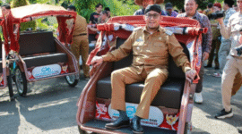 Bupati Sumenep, Achmad Fauzi, mencoba mengendarai becak listrik usai menyerahkan bantuan secara simbolis kepada para abang becak di Pendopo Agung. (Foto:Klik Times). 