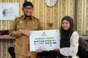 LUAR BIASA: Bupati Achmad Fauzi Wongsojudo menyerahkan secara simbolis bantuan beasiswa kepada mahasiswi asal Sumenep, Nanda Balqis. 