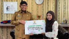 LUAR BIASA: Bupati Achmad Fauzi Wongsojudo menyerahkan secara simbolis bantuan beasiswa kepada mahasiswi asal Sumenep, Nanda Balqis. 