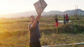 Ayik, Warga Desa Bragung, Kecamatan Guluk-guluk, tampak antusias menerbangkan layangan di sela musim tembakau (Foto/Klik Times).